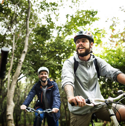 Group of friends ride mountain bike in the forest together