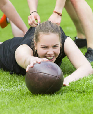 Meisjes spelen samen rugby in de zomer