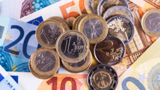 Euromunten 1 en 2 euro bovenop eurobiljetten van verschillende waardes