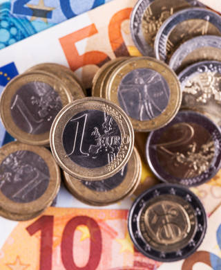 Euromunten 1 en 2 euro bovenop eurobiljetten van verschillende waardes