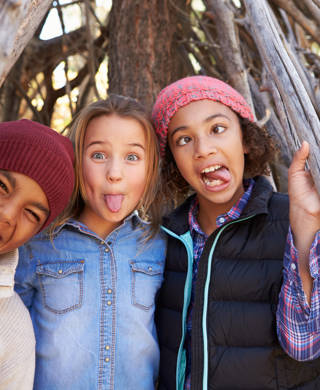 Group Of Children Playing In Forest Camp Together