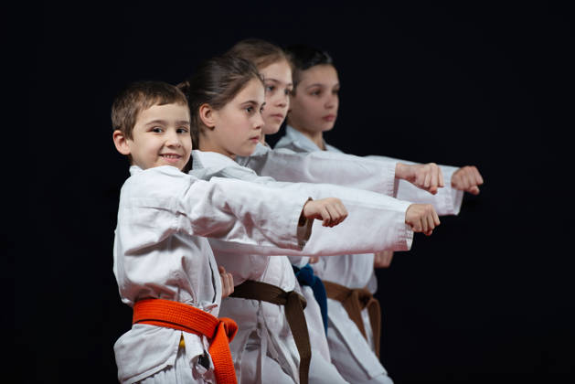 Kinderen in kimono met vuist vooruit