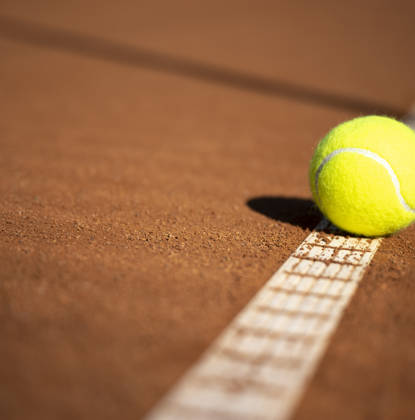 Tennisbal op gravel tennisveld