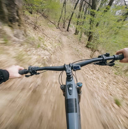Motion blur as young man rides through springtime forest, in the Swiss Alps