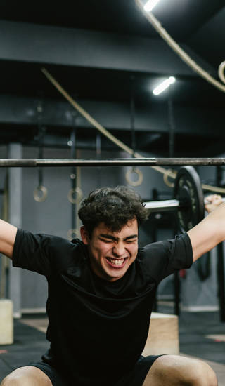 Jonge man duwt gewicht omhoog