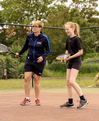 leerling krijgt tennisles van lesgever