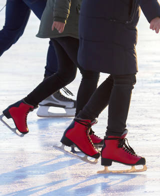 different people are actively skating on an ice rink. hobbies and leisure. winter sports