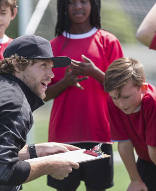 A coach with a group of young soccer players.