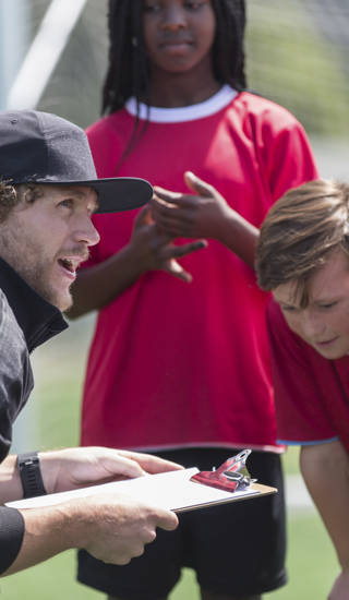 A coach with a group of young soccer players.