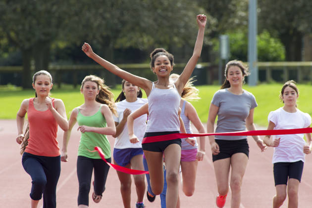 Groepje tieners lopen door het eindlint van de finish