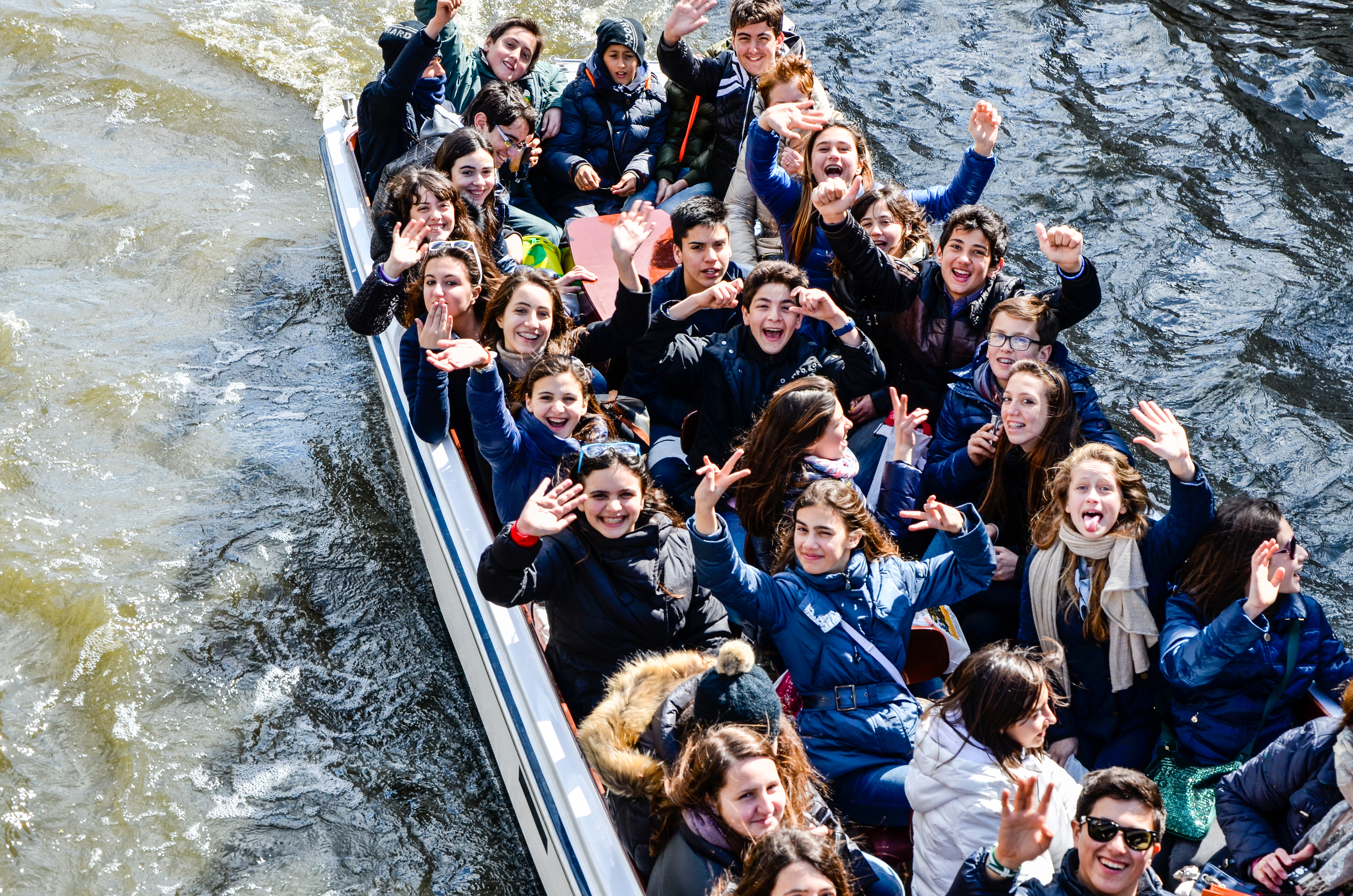 Bruges, Belgium - April 15, 2010: Teenager students are having fun on a tour boat during their educational tour in Bruges, Belgium.