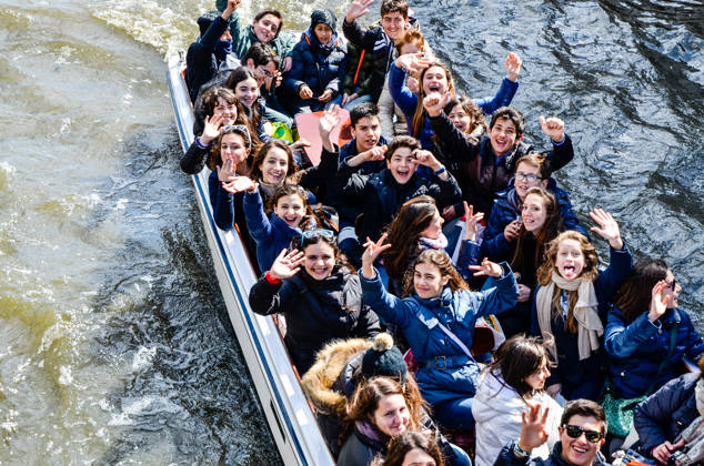 Bruges, Belgium - April 15, 2010: Teenager students are having fun on a tour boat during their educational tour in Bruges, Belgium.