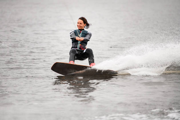 Vrouw aan touw op waterskilatten