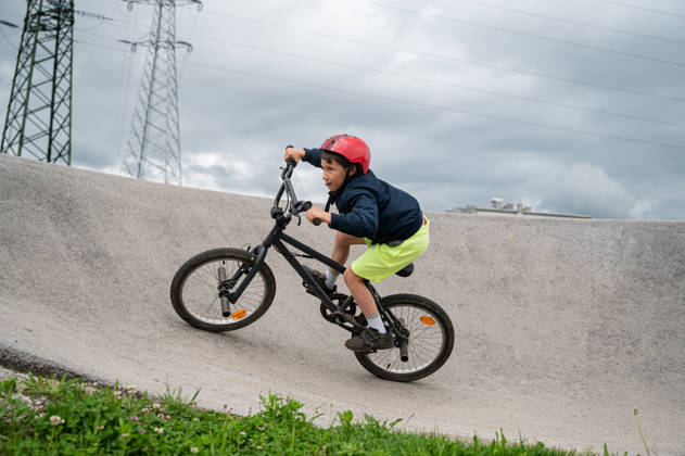 Jonge jongen rijdt met BMW op een pumptrack