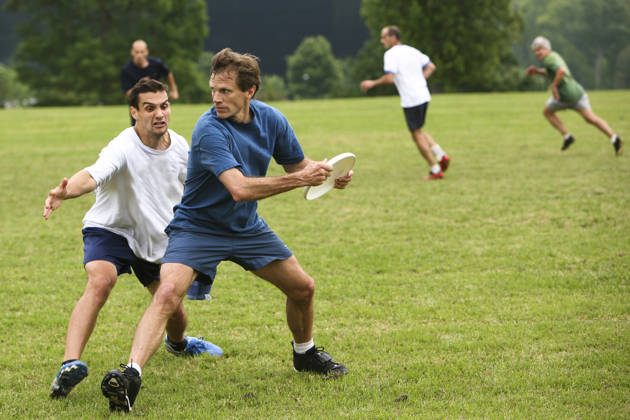 Wedstrijd frisbee met twee mannen in het park