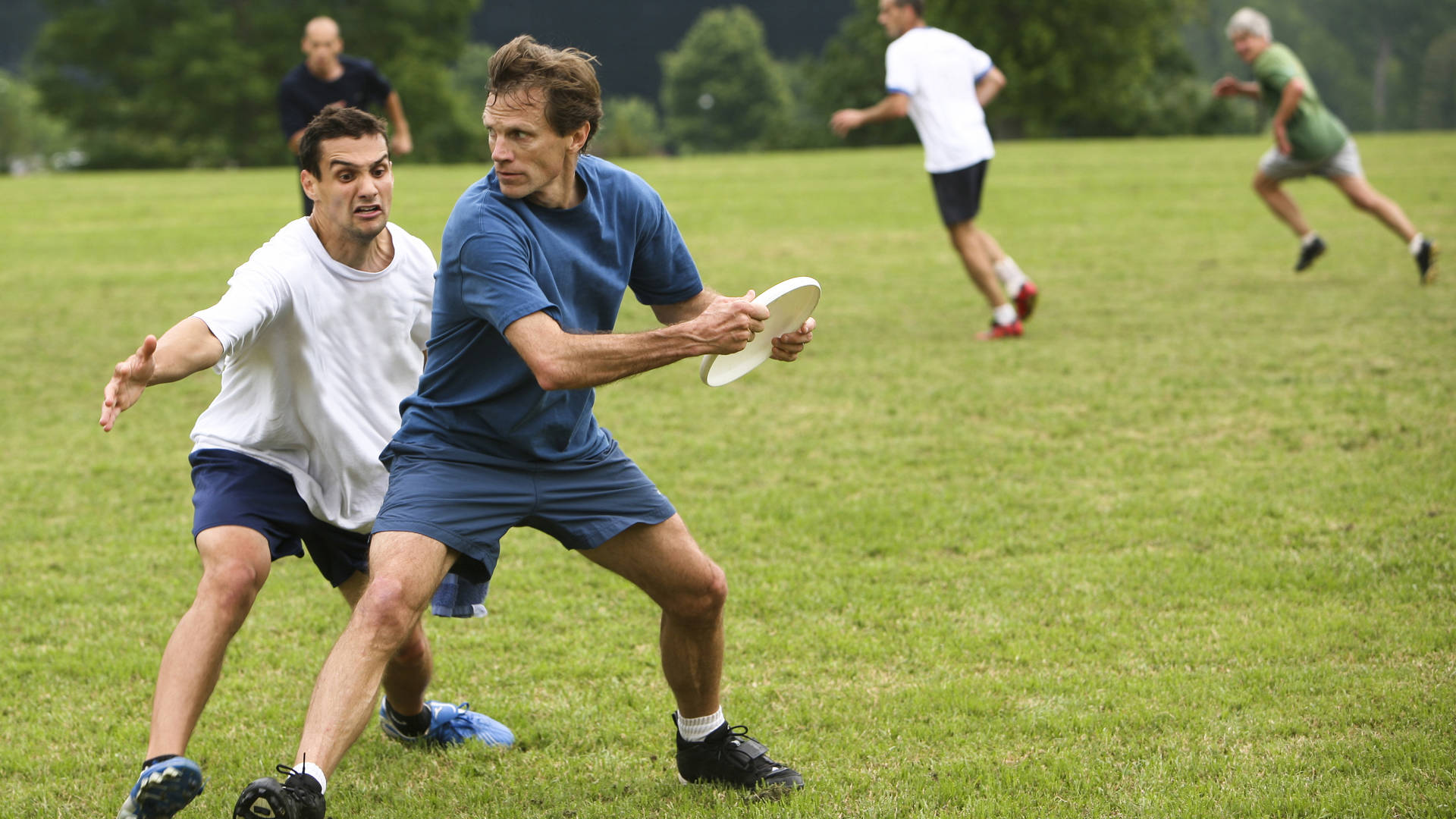Wedstrijd frisbee met twee mannen in het park