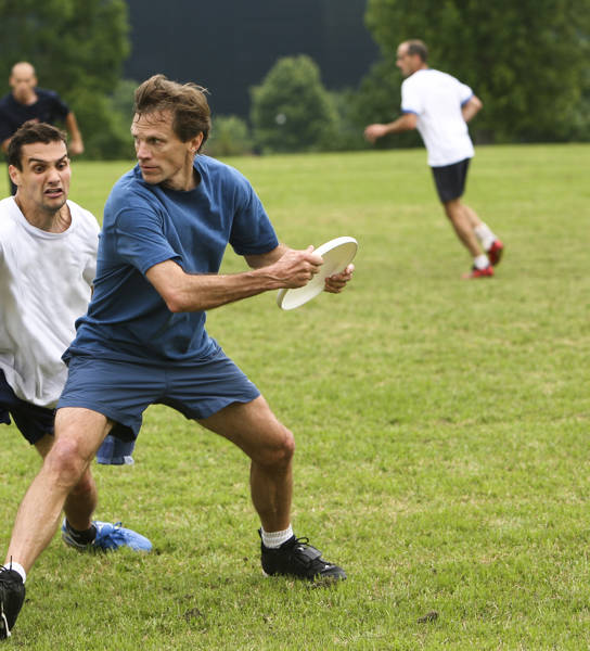 Wedstrijd frisbee met twee mannen in het park