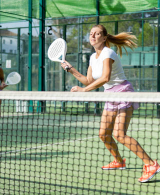 jonge vrouw speelt gefocust padel