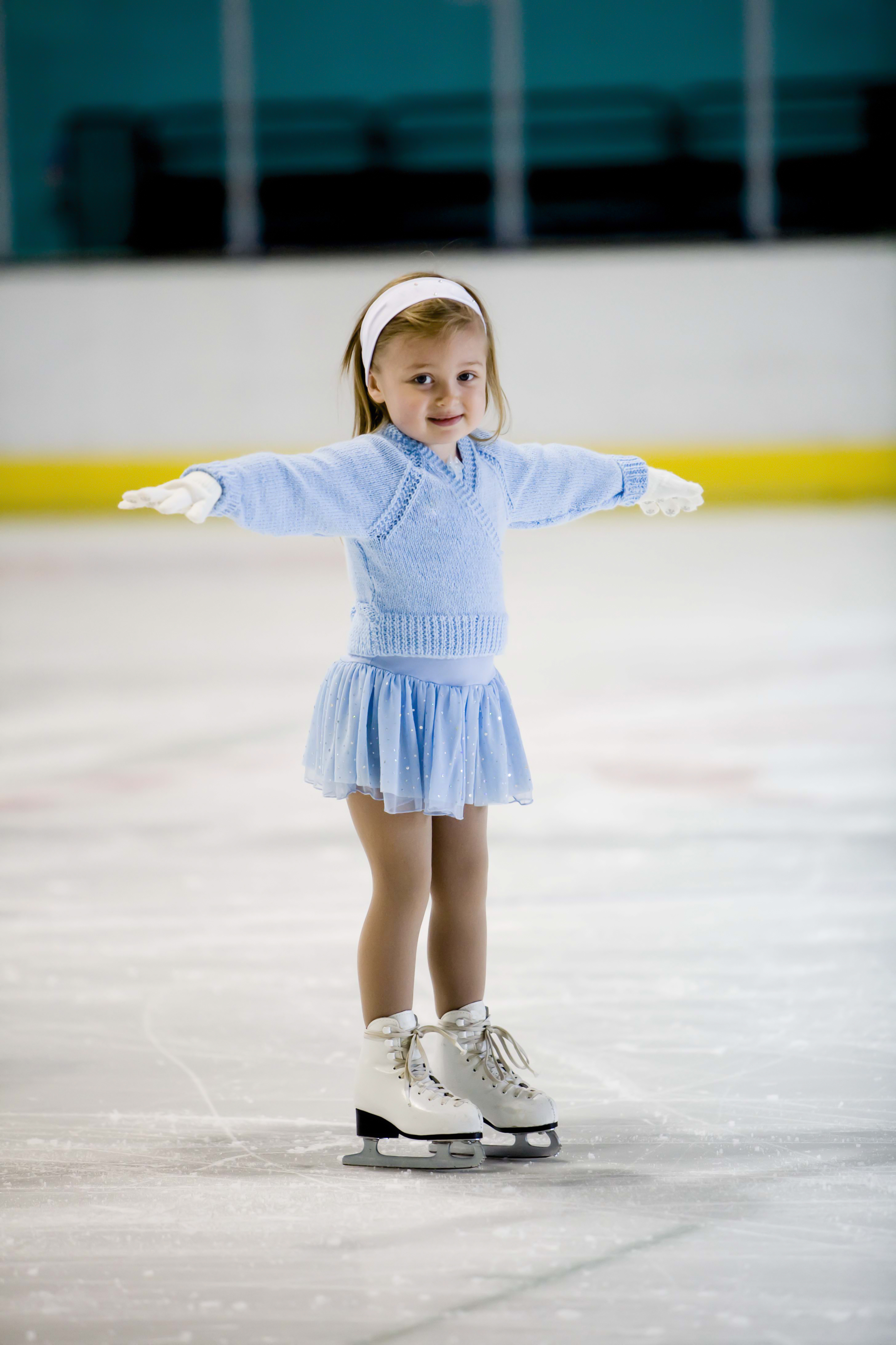 A confident little girl skates on the ice