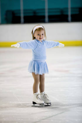 A confident little girl skates on the ice