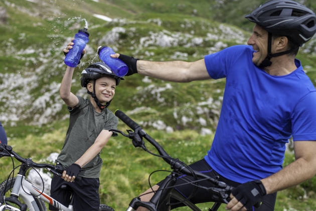 Vader en zoon rijden met mountainbikefiets door de bergen