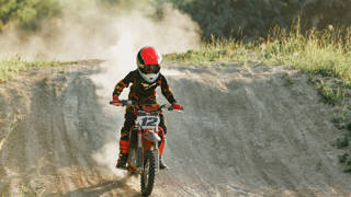 Motorcrosser met helm op rijdt op parcours