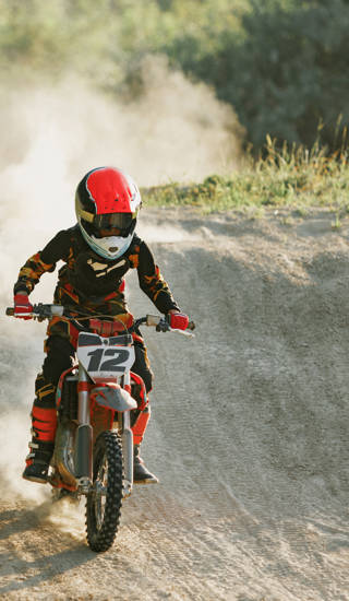 Motorcrosser met helm op rijdt op parcours