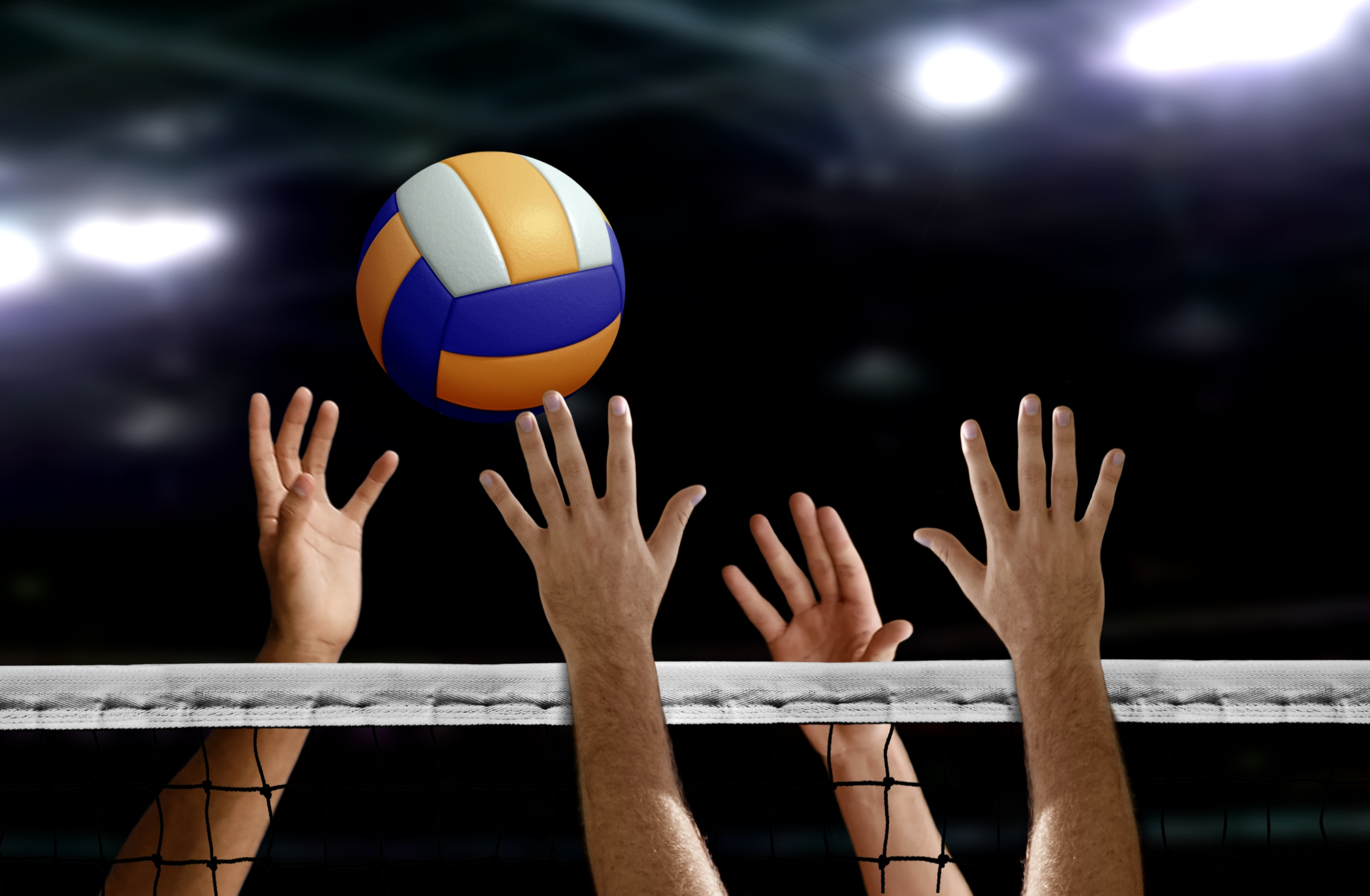 Volleyballers blokkeren bal aan net