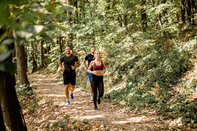 Fitness instructors running in the forest. Beautiful people doing workout.