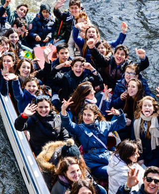 Bruges, Belgium - April 15, 2010: Teenager students are having fun on a tour boat during their educational tour in Bruges, Belgium.