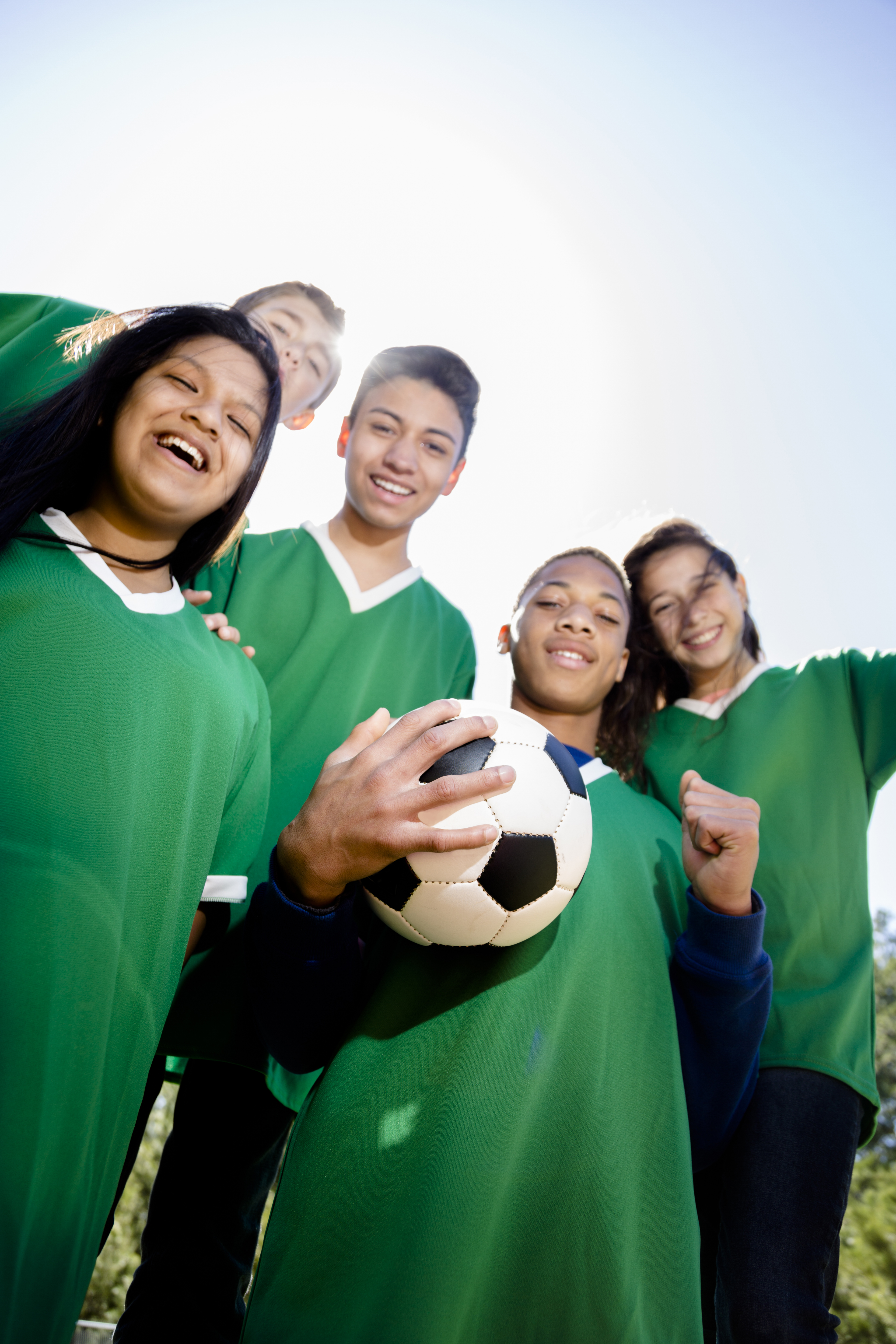 geef tieners een stem
5 rechtopstaande jongeren in groen voetbaltrui met bal