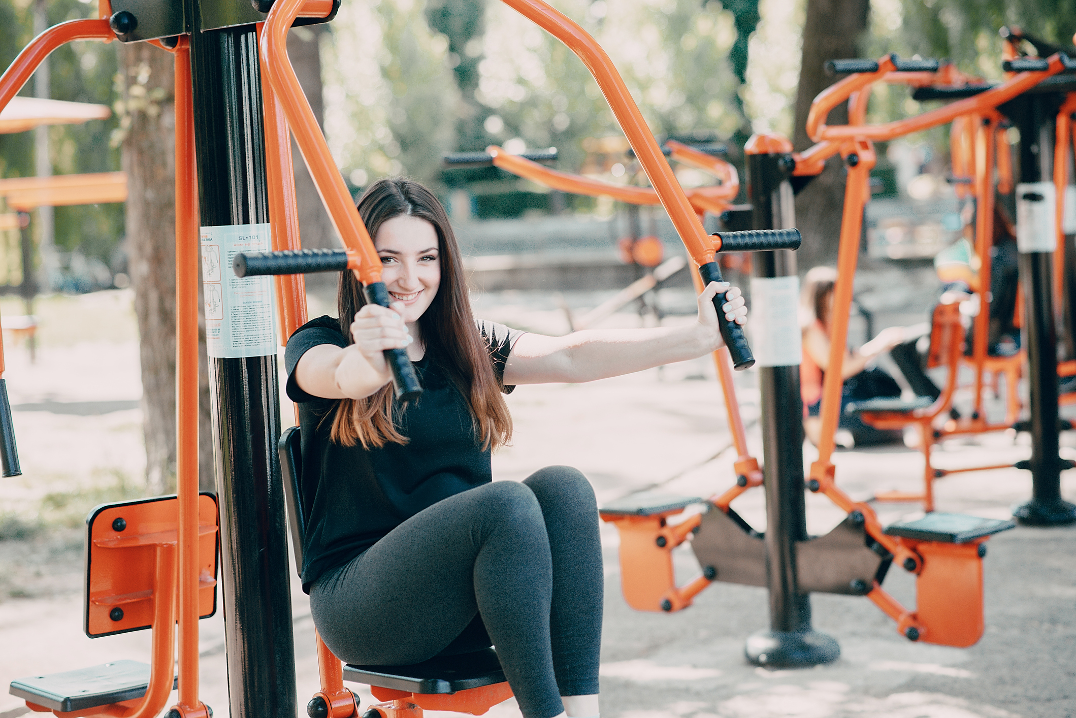  Fitness girl walks in the park and engaged in various exercises with weights and mat