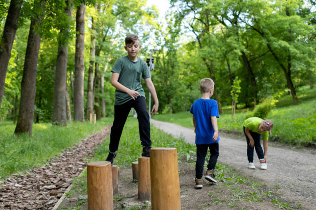 Children are playing at the public park on outdoor exercise equipment. A family having fun. Healthy physical activities simple concept. Active children, fit sporty children exercising.
