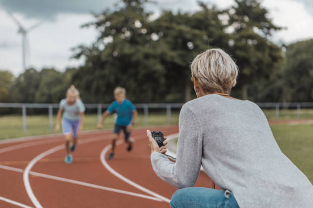 trainer chronometreert twee kinderen