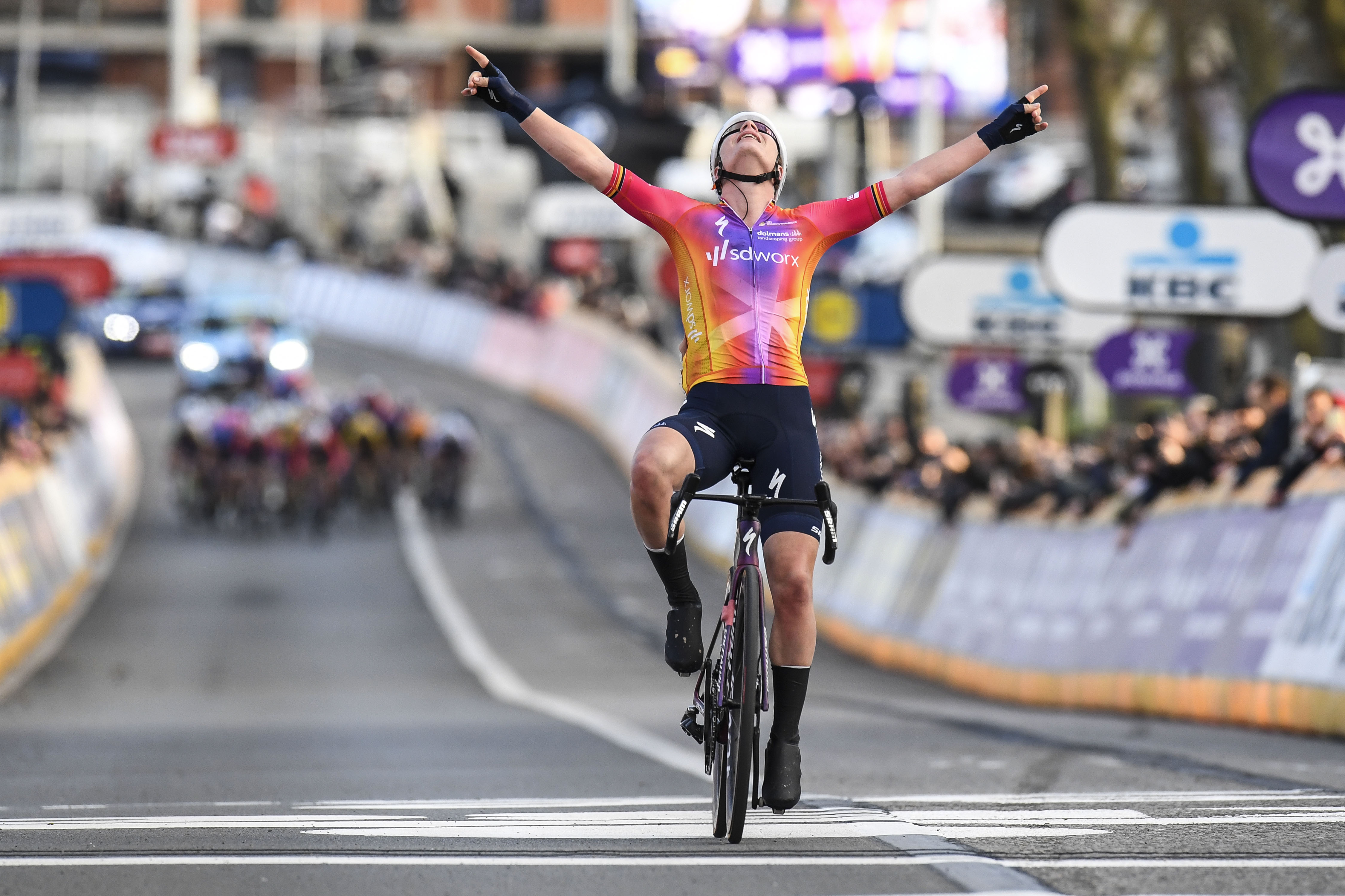Belgian Lotte Kopecky of SD Worx celebrates as she crosses the finish line to win the women's one-day cycling race Omloop Het Nieuwsblad, for the first time part of the Women's World Tour races, 132,2 km from Gent to Ninove, Saturday 25 February 2023. BELGA PHOTO TOM GOYVAERTS
