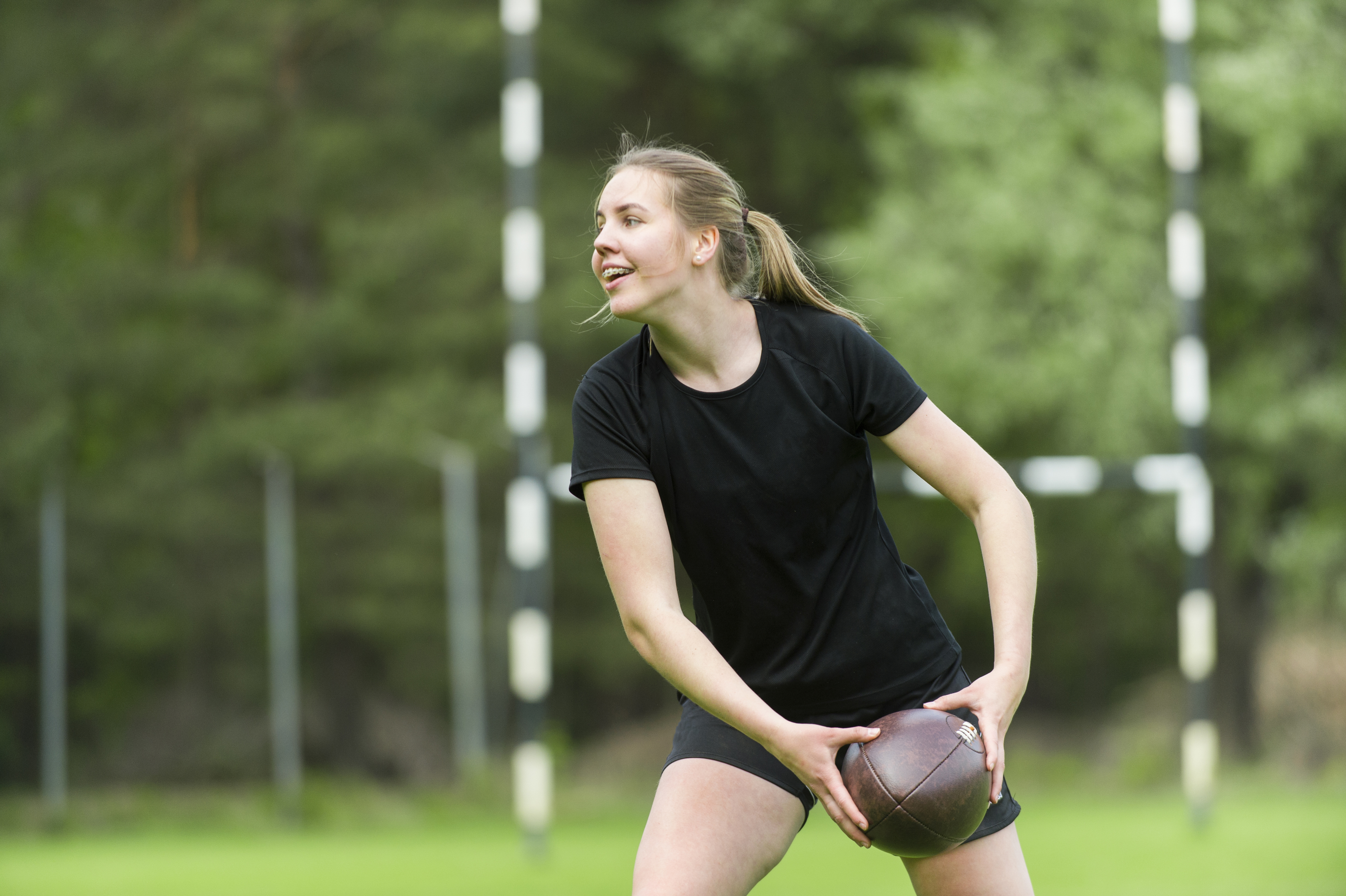 Meisje speelt rugby in het park in de zomer 