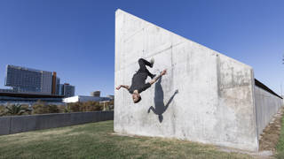 Jongen doet backflip tegen muur