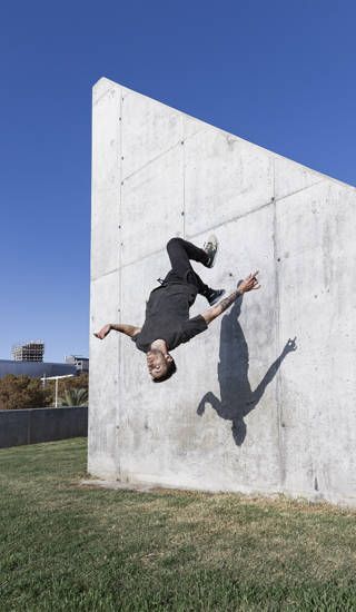 Jongen doet backflip tegen muur