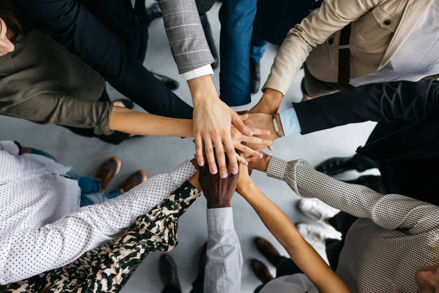 Verschillende handen op elkaar van multiculturele groep mensen