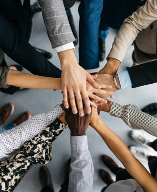 Verschillende handen op elkaar van multiculturele groep mensen
