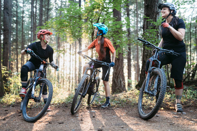 A group of friends has fun riding beautiful mountain bike paths and trails in the Pacific Northwest. Horizontal image with copy space.