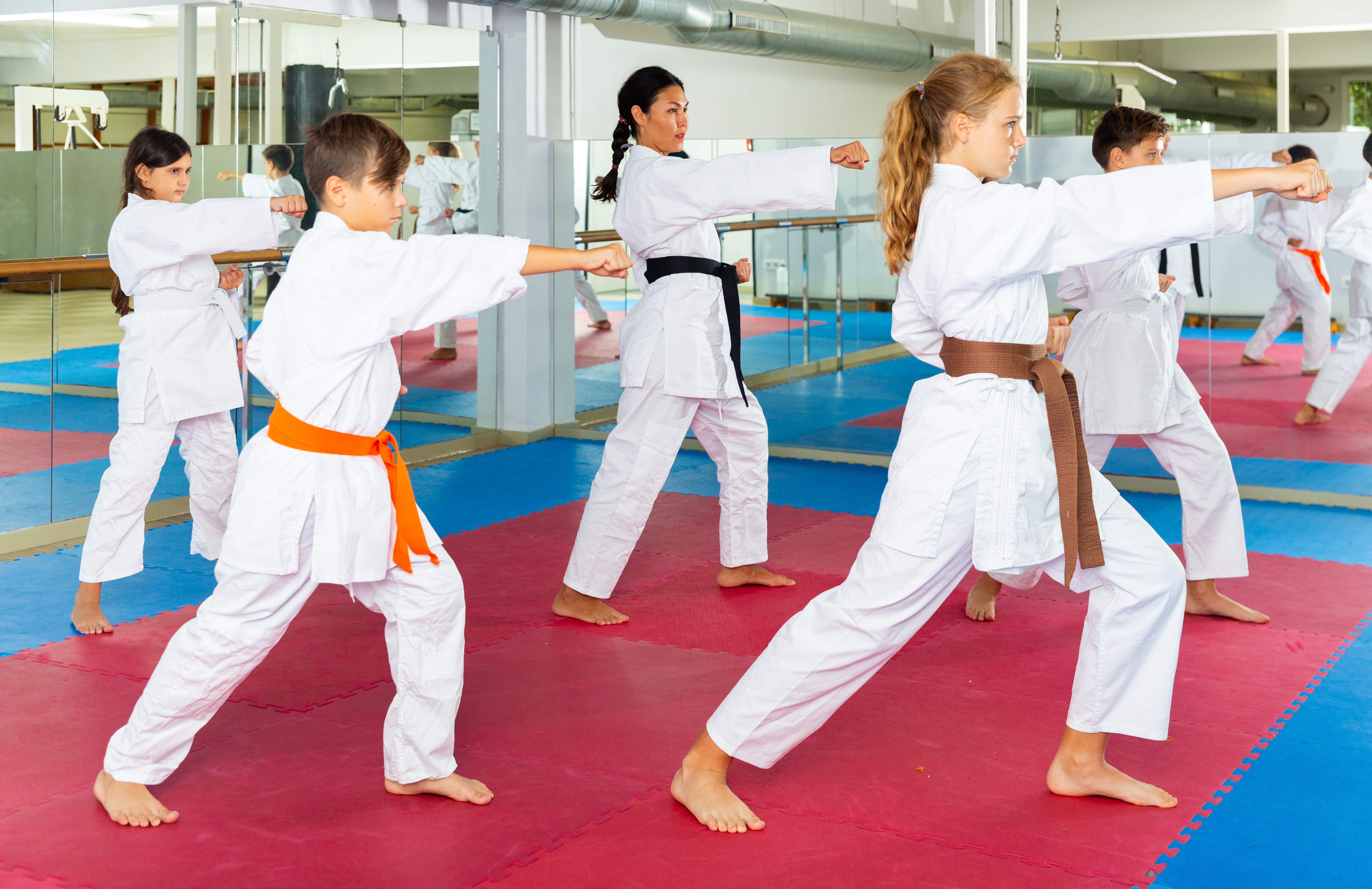 jongeren in kimono met vuist vooruit en benen gespreid
