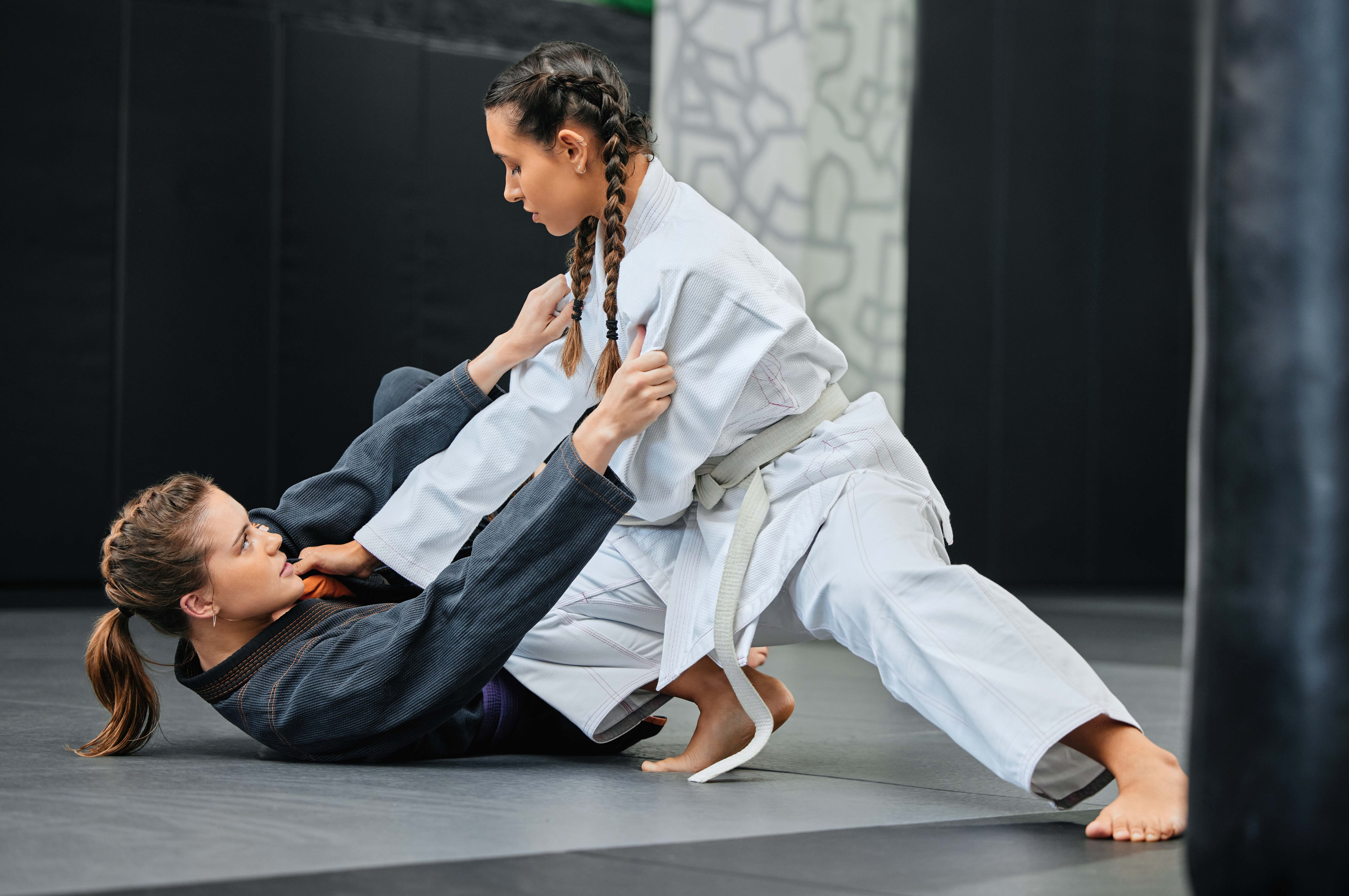 Twee jonge dames vechten met elkaar, ene in witte kimono, de andere in grijze kimono
