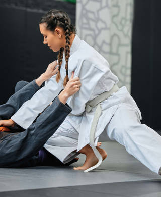 Twee jonge dames vechten met elkaar, ene in witte kimono, de andere in grijze kimono