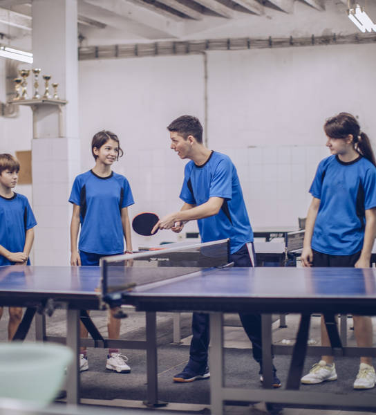 Groepje tafeltennisspelers gemengd tijdens de training