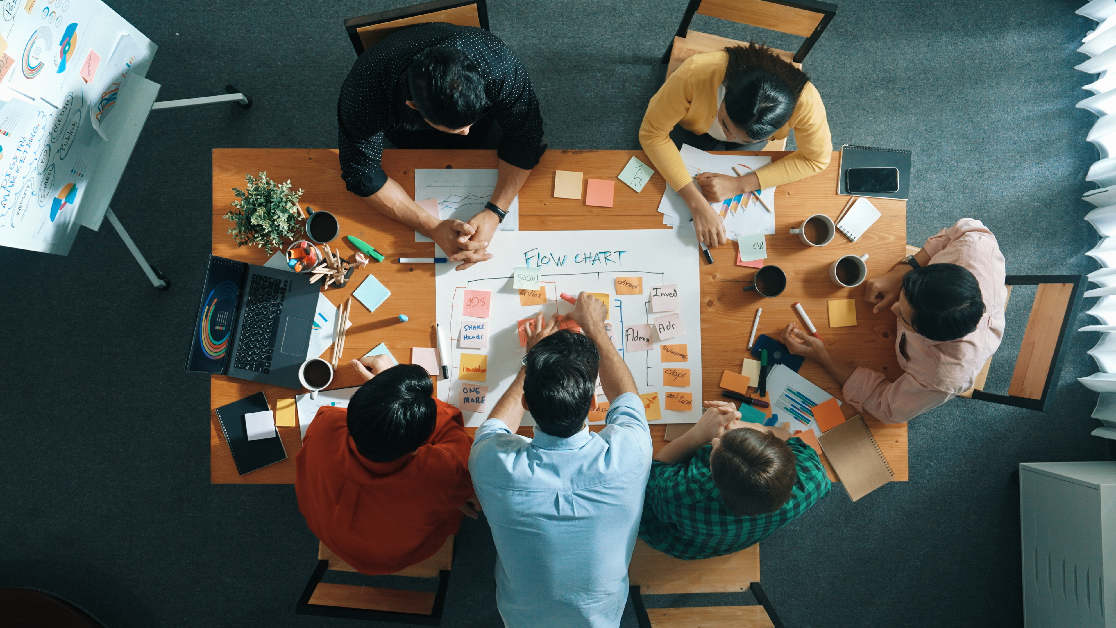 Top view of smart business man put scrum board on table at meeting room while marketing team preparing marker and sticky notes for making task board for managing work flow in work place. Convocation.