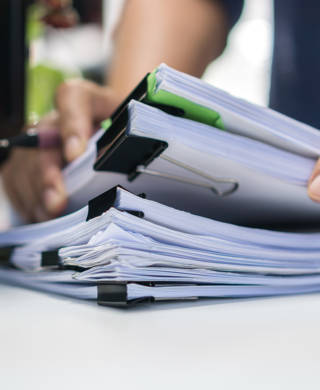 Paperwork files searching information business concept, Businessman hands typing keyboard computer, working in stacks of report papers and piles of unfinished documents achieves on office desk