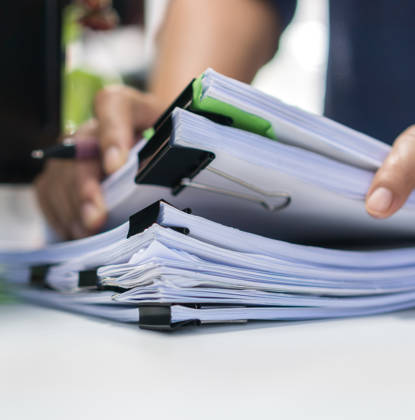 Paperwork files searching information business concept, Businessman hands typing keyboard computer, working in stacks of report papers and piles of unfinished documents achieves on office desk