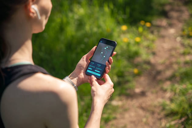 A woman analysis performance of the morning training on a smartphone