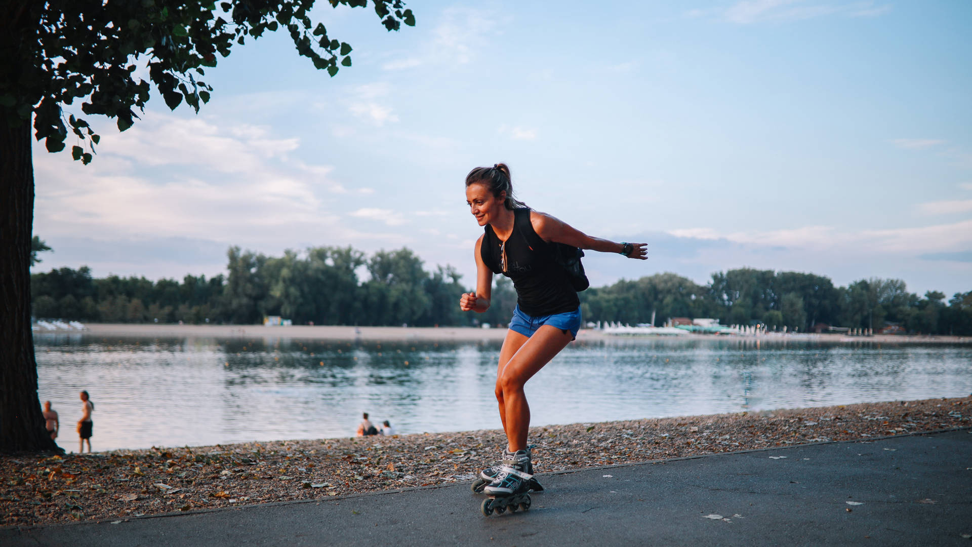 Meisje dat aan het rolschaatsen is op een pad langs het water